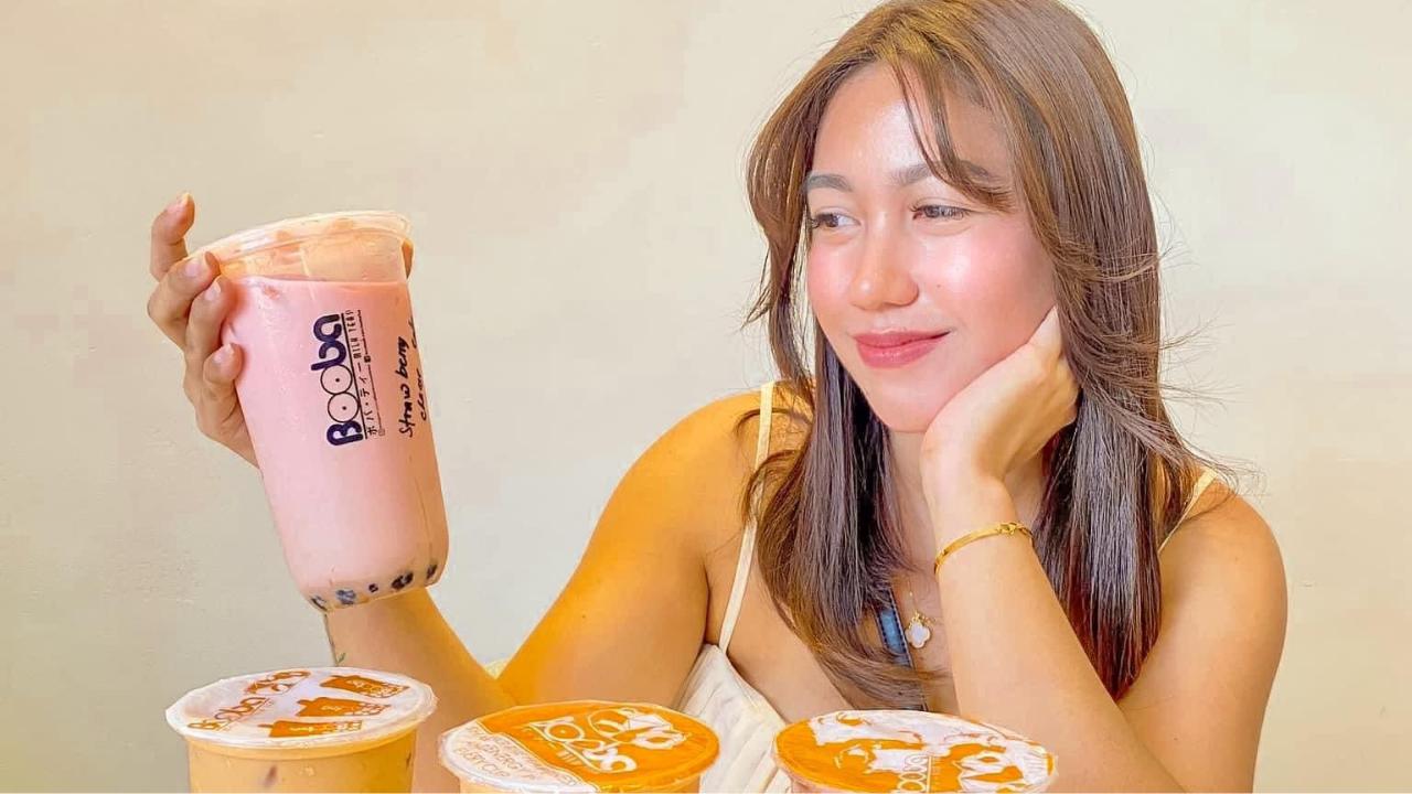 Woman holding a large cup of pink bubble tea