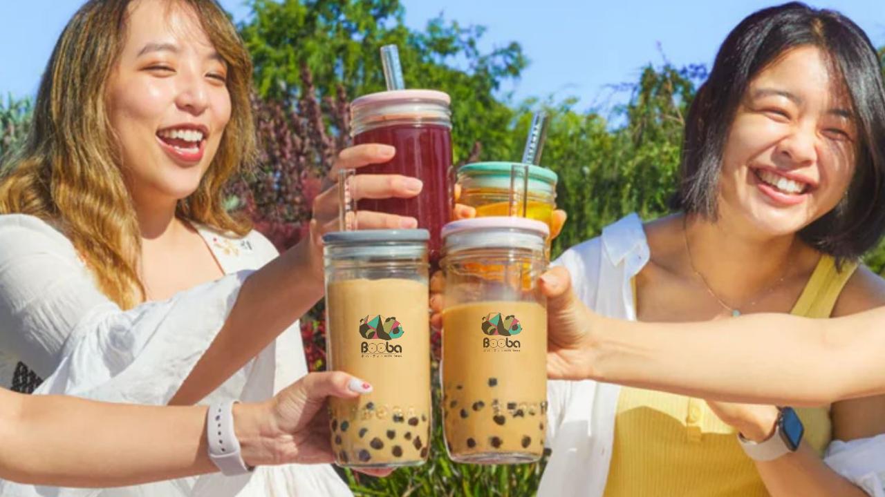 Two women toasting with bubble tea outdoors